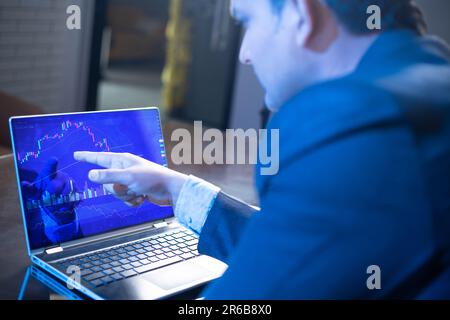 Homme d'affaires ou négociant boursier travaillant sur l'écran d'ordinateur portable, le marché financier, graphique de graphique , Crypto et le marché de forex. Banque D'Images