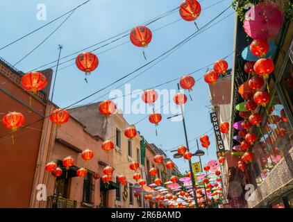 Lanternes chinoises en papier rouge et parasols suspendus au-dessus de la rue dans Chinatown, Mexico, Mexique annonçant divers restaurants Banque D'Images