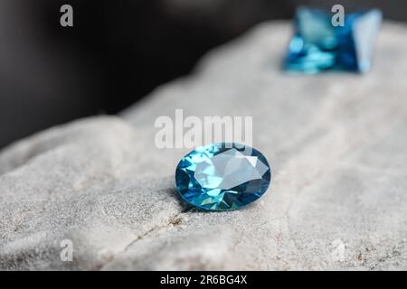 Une pierre précieuse saphir bleu naturel scintillant sur une surface rocheuse Banque D'Images