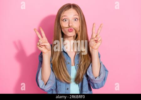 Photo portrait d'une jolie jeune fille montrant un double V-signe cheveux moustache habillée ensemble denim élégant isolé sur fond rose Banque D'Images