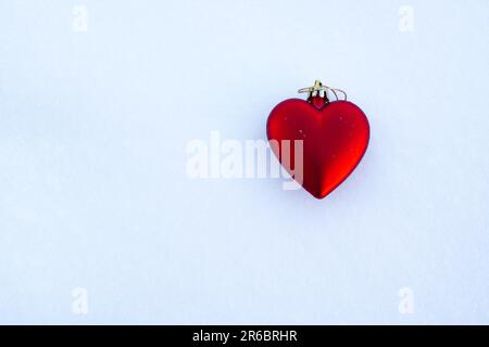 Décoration d'arbre de Noël en forme de cœur rouge sur une surface blanche Banque D'Images