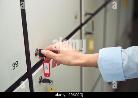 Adulte ouvrant la porte fermée du casier de rangement Banque D'Images