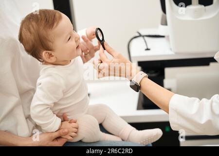 Un oculiste pédiatrique vérifie la vision de l'enfant pendant la consultation Banque D'Images