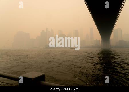 Brooklyn, NY, États-Unis. 8th juin 2023. Mercredi, le pont Broklyn, envoûté par la fumée, enveloppait NYC, en provenance des feux de forêt canadiens qui ont explosé vers le sud. Les niveaux de qualité de l'air ont atteint un niveau record à New York avec des chiffres atteignant 342 sur l'IQA. Les autorités de New York ont conseillé aux résidents de rester à l'intérieur, de limiter l'exposition à l'extérieur et de porter des masques à l'extérieur. On a dit aux populations vulnérables, comme les enfants et les adultes plus âgés, d'éviter d'aller à l'extérieur. Banque D'Images