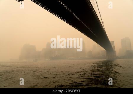 Brooklyn, NY, États-Unis. 8th juin 2023. Mercredi, le pont Broklyn, envoûté par la fumée, enveloppait NYC, en provenance des feux de forêt canadiens qui ont explosé vers le sud. Les niveaux de qualité de l'air ont atteint un niveau record à New York avec des chiffres atteignant 342 sur l'IQA. Les autorités de New York ont conseillé aux résidents de rester à l'intérieur, de limiter l'exposition à l'extérieur et de porter des masques à l'extérieur. On a dit aux populations vulnérables, comme les enfants et les adultes plus âgés, d'éviter d'aller à l'extérieur. Banque D'Images