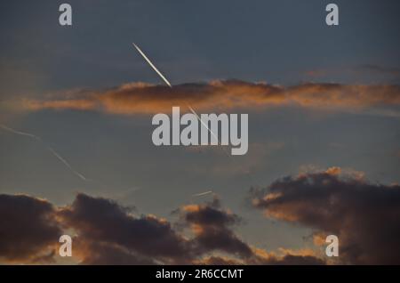 Avion à réaction dans un ciel nuageux au coucher du soleil avec des pistes jaunes et noires au-dessus de Sofia, Bulgarie Banque D'Images