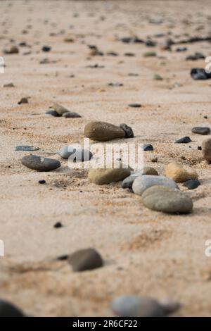 Galets sur la plage de sable Banque D'Images