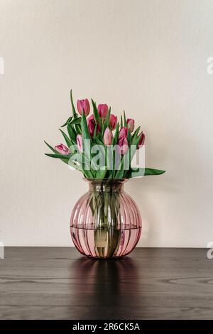 Belle décoration de printemps.tulipes roses violettes dans vase en verre.bouquet de fleurs de tulipe fraîches.Voir avec espace de copie.carte de vœux.Fête des mères de femme.Minimali Banque D'Images