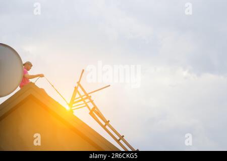 La construction et la construction d'une nouvelle maison extérieure en bois sont en cours. Un constructeur et un couvreur qualifiés installent et réparent des bardeaux Banque D'Images