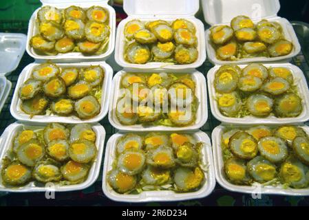 Les snacks préférés des colporteurs sont les snacks de caille ou les œufs de caille frits. Les œufs de caille sont frits avec des légumes, du chou et dans une tasse en mousse. Banque D'Images