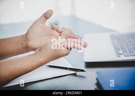 Arthrite personne, doigt femme mal de travailler dans le bureau. Concept Office syndrome douleur de main de la maladie professionnelle, femme ayant douleur de poignet Banque D'Images