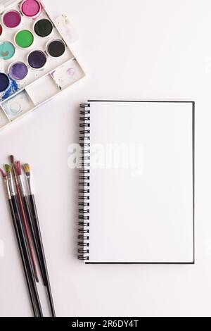 Gros plan de peintures, carnets et pinceaux avec espace de copie sur fond blanc. Retour à l'école, art, peinture, matériel scolaire, apprentissage, école et ed Banque D'Images