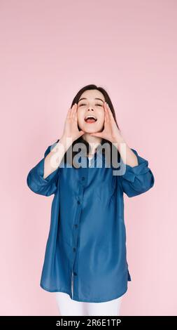 Joie expressive : gros plan Portrait des mains d'une jeune femme gaie près de la bouche ouverte, transmettant l'excitation et le bonheur avec un sourire en terre cuite, isolé Banque D'Images