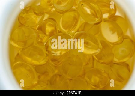 beaucoup de capsules de gélatine jaune sur fond clair. vitamines omega, gros plan, macro. Banque D'Images