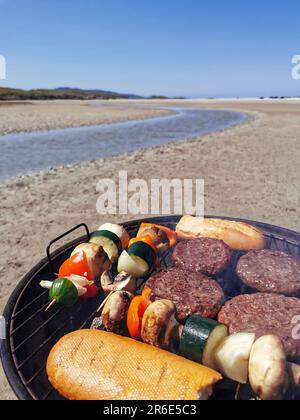 Faire un barbecue sur une plage de sable entourée de montagnes à Silver Strand, Thallabawn, Doovilra, Louisburgh, Co Mayo, Irlande Banque D'Images