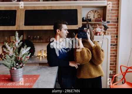 jeune couple est photographié serrant dans la cuisine pendant noël Banque D'Images