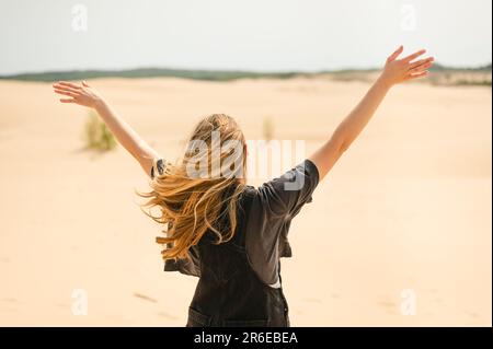 Vue arrière d'une femme aux bras dépassant les dunes de sable du Michigan Banque D'Images