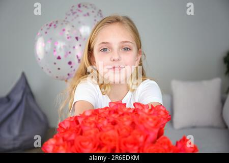 Une fille souriant donne un bouquet de fleurs pour la fête des mères. Banque D'Images