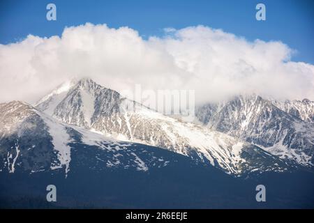 arrière-plan nature de la puissante crête de tatra au printemps à midi. sommets rocheux enneigés sous un ciel nuageux Banque D'Images