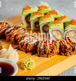 Une assiette avec un assortiment de petits pains à sushis japonais colorés, garnie de œufs de poisson, de graines de sésame et d'oignons verts Banque D'Images