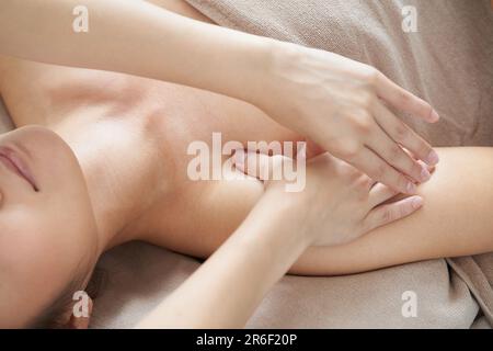 Une femme bénéficie d'un massage à la décoloration dans un salon de beauté lumineux Banque D'Images