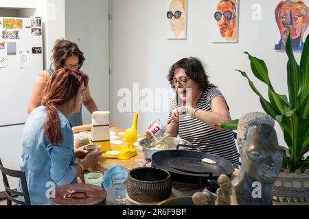 Trois sœurs travaillent ensemble pour préparer les Calzones remplies de fromage une nourriture laitière juive traditionnelle mangée sur Shavuot Banque D'Images