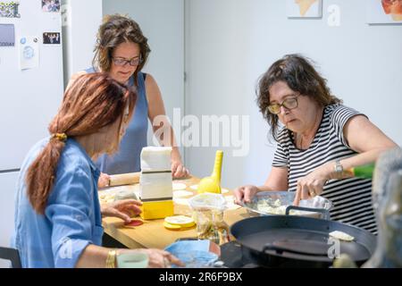 Trois sœurs travaillent ensemble pour préparer les Calzones remplies de fromage une nourriture laitière juive traditionnelle mangée sur Shavuot Banque D'Images