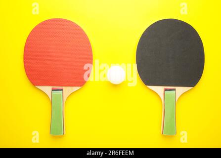 Raquettes et balles de ping-pong sur fond jaune. Vue de dessus Banque D'Images