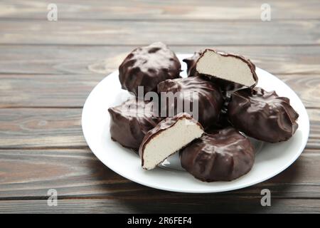 Guimauves enrobées de chocolat sur plaque sur fond marron. Vue de dessus Banque D'Images