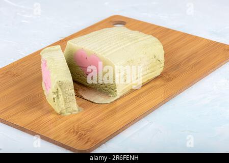 Glace à la pistache avec une couche en forme de coeur de framboise sur une planche à découper. Copier l'espace. Banque D'Images