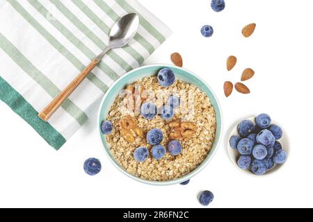 Un bol en céramique rempli de flocons d'avoine sains pour le petit-déjeuner, avec une variété de fruits frais pour ajouter de la nourriture et de la saveur Banque D'Images