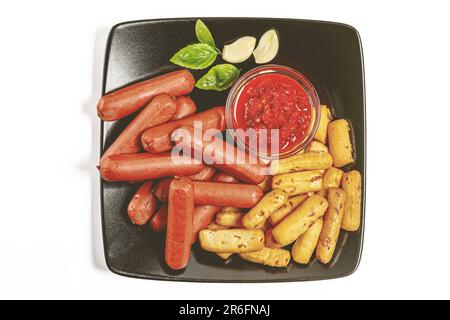 Une assiette avec plusieurs hot dogs fraîchement cuits, des frites et des garnitures de salsa disposées de manière appétissante Banque D'Images