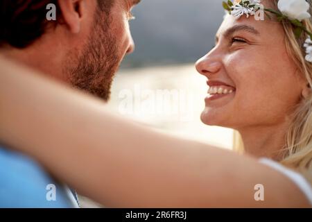 Gros plan portrait de la mariée joyeuse avec grand sourire regardant son mari. Couple en bord de mer. Mariage, lune de miel, concept d'amour Banque D'Images