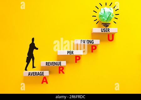 Revenu moyen ARPPU par symbole d'utilisateur payeur. Mots de concept ARPPU revenu moyen par utilisateur payant sur bloc de bois. Magnifique fond jaune. Entreprise Banque D'Images