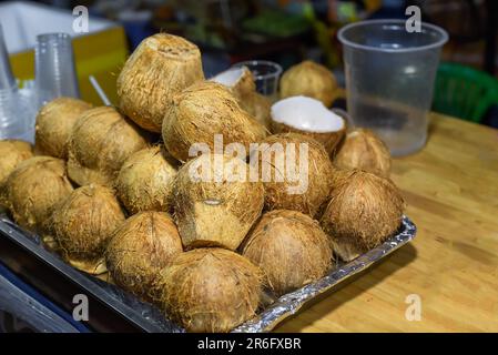 Petits noix de coco entières et coupées en deux pour la préparation de la crème glacée au vietnam Banque D'Images