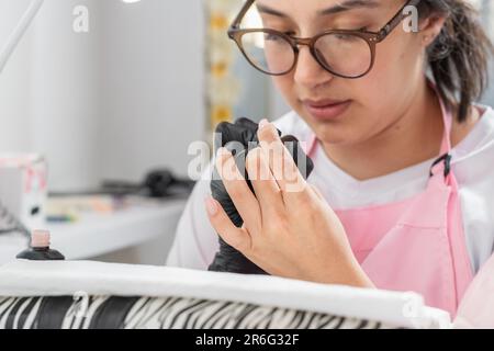 belle jeune femme très concentrée sur faire une manucure sur elle-même Banque D'Images