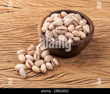 Pistaches grillées salées sur un bol sur une table en bois. Banque D'Images