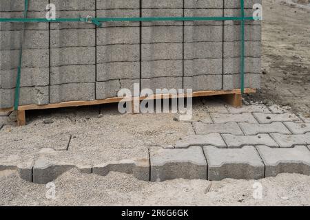 Palette avec dalles de pavage grises, processus de réparation des routes, gros plan, accent sélectif sur les carreaux, reconstruction saisonnière de la chaussée dans les sentiers de randonnée dans les parcs Banque D'Images