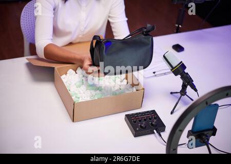 Gros plan image de la mode blogger déballage sac en similicuir et film vidéo Banque D'Images