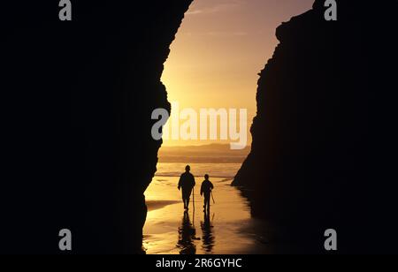 Mère et fille ont silhoueté marchant dans la formation rocheuse le long de la côte de l'Oregon, parc d'État du Cap Sebastian Banque D'Images