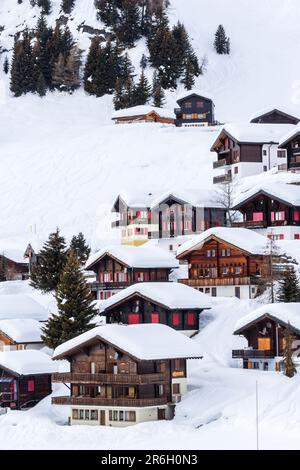 Chalets en bois sur la montagne enneigée dans la station d'hiver Riederalp, Suisse. Banque D'Images