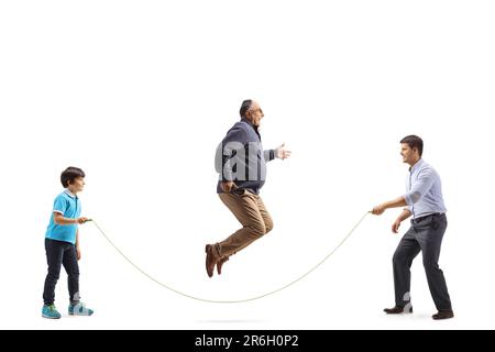 Photo pleine longueur de l'homme et du père mûrs avec son fils jouant une corde à sauter isolée sur fond blanc Banque D'Images