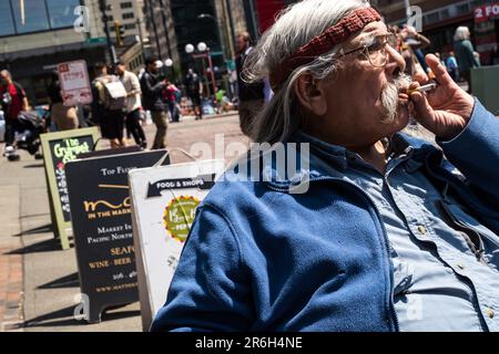 Seattle, États-Unis. 1 juin 2023. Une personne élégante assise au soleil au célèbre marché de Pike place. Banque D'Images