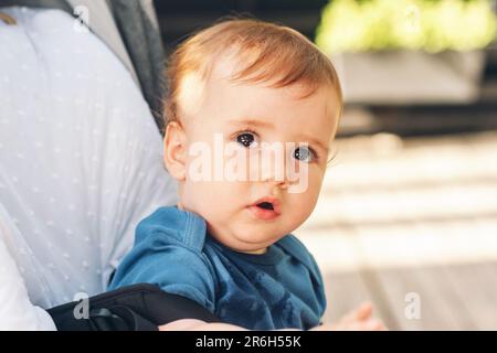 Portrait en gros plan à l'extérieur d'un adorable bébé à tête rouge assis dans un buggy Banque D'Images