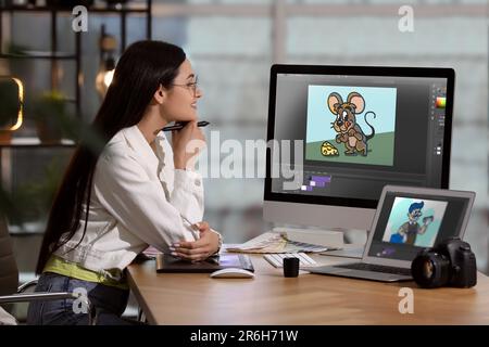 Animator travaillant avec un ordinateur et un ordinateur portable. Illustrations à l'écran Banque D'Images