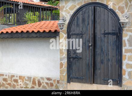 Entrée du bâtiment avec belle porte en bois voûtée dans le mur en pierre à l'extérieur Banque D'Images