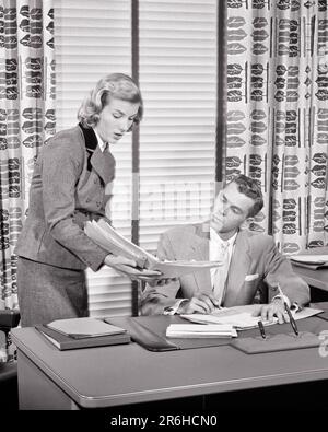 1950S FEMME ASSISTANT MONTRANT DES DOSSIERS À UN JEUNE HOMME D'AFFAIRES ASSIS AU BUREAU AU BUREAU AVEC DES STORES VÉNITIENS ET UN IMPRIMÉ FEUILLES RIDEAUX - O1118 HAR001 HARS ASSISTANT VIE SATISFACTION COMMIS FEMMES MONTRANT DES BLINDS GESTIONNAIRE ASSIS ESPACE DE COPIE AMITIÉ FEMMES HOMMES CADRES VENETIAN B&W FEMME D'AFFAIRES DÉPOSE DES OBJECTIFS BLANC COLLIER COSTUME ET CRAVATE VENDANT DES FEUILLES DE DÉCOUVERTE ET DES RIDEAUX DE LEADERSHIP DE GRAND ANGLE BUREAU OPPORTUNITÉS DE TRAVAIL PROFESSIONS BUSINESS SUIT PATRONS GAL VENDREDI ADMINISTRATEUR SECRÉTAIRES ÉLÉGANT SOUTIEN FEMMES D'AFFAIRES COOPERATION MANAGERS MOYENNE-ADULTE HOMME MOYENNE-ADULTE FEMME MOYENNE-ADULTE VENDEURS Banque D'Images