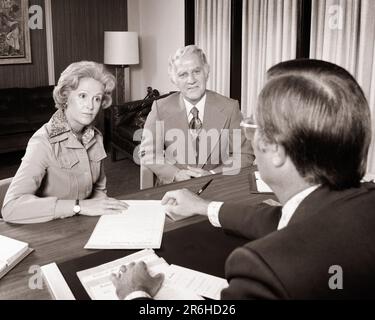 1970S RENCONTRE HOMME ET FEMME D'ÂGE MÛR AVEC HOMME D'AFFAIRES VU DE DERRIÈRE LE CONSEILLER FINANCIER AVOCAT SE PRÉPARANT À SIGNER LE DOCUMENT OU LA VOLONTÉ - O4108 HAR001 HARS STYLE DE COMMUNICATION SÉCURITÉ TRAVAIL D'ÉQUIPE INFORMATION JOIE STYLE DE VIE FEMMES AÎNÉES ÉPOUSES ÉPOUX PRÉPARANT L'ESPACE DE COPIE DEMI-LONGUEUR LES FEMMES SERONT LES HOMMES RETRAITE SENIOR HOMME ADULTE SENIOR B&W D'ÂGE MOYEN PARTENAIRE FINANCIER OBJECTIFS RETRAITÉ COSTUME ET CRAVATE DOCUMENTS VIEUX ÂGE FEMME D'ÂGE MOYEN OLDSTERS HAUT ANGLE OLDSTER STRATÉGIE DE PROTECTION DES DOCUMENTS ET LES PROFESSIONS D'AUTORITÉ ANCIENS SIGNATURE SOUTIEN OU CONSEILLER COOPÉRATION DU PROCUREUR IDÉES MI-ADULTES Banque D'Images