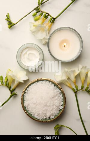 Composition de la nappe avec différents produits de spa et fleurs sur une table en marbre blanc Banque D'Images