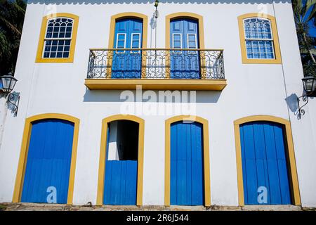 Vue sur un ensemble de maisons coloniales le long d'une rue pavée par une journée ensoleillée dans la ville historique de Paraty, Brésil, patrimoine mondial de l'UNESCO Banque D'Images